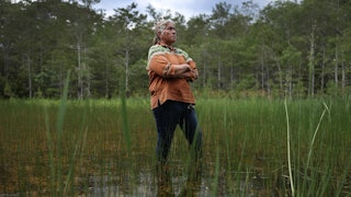 Betty Osceola stands in the Everglades a few yards from the front entrance to "Alligator Alcatraz" at the Dade-Collier Training and Transition Airport on July 10, 2025 in Ochopee, Florida.