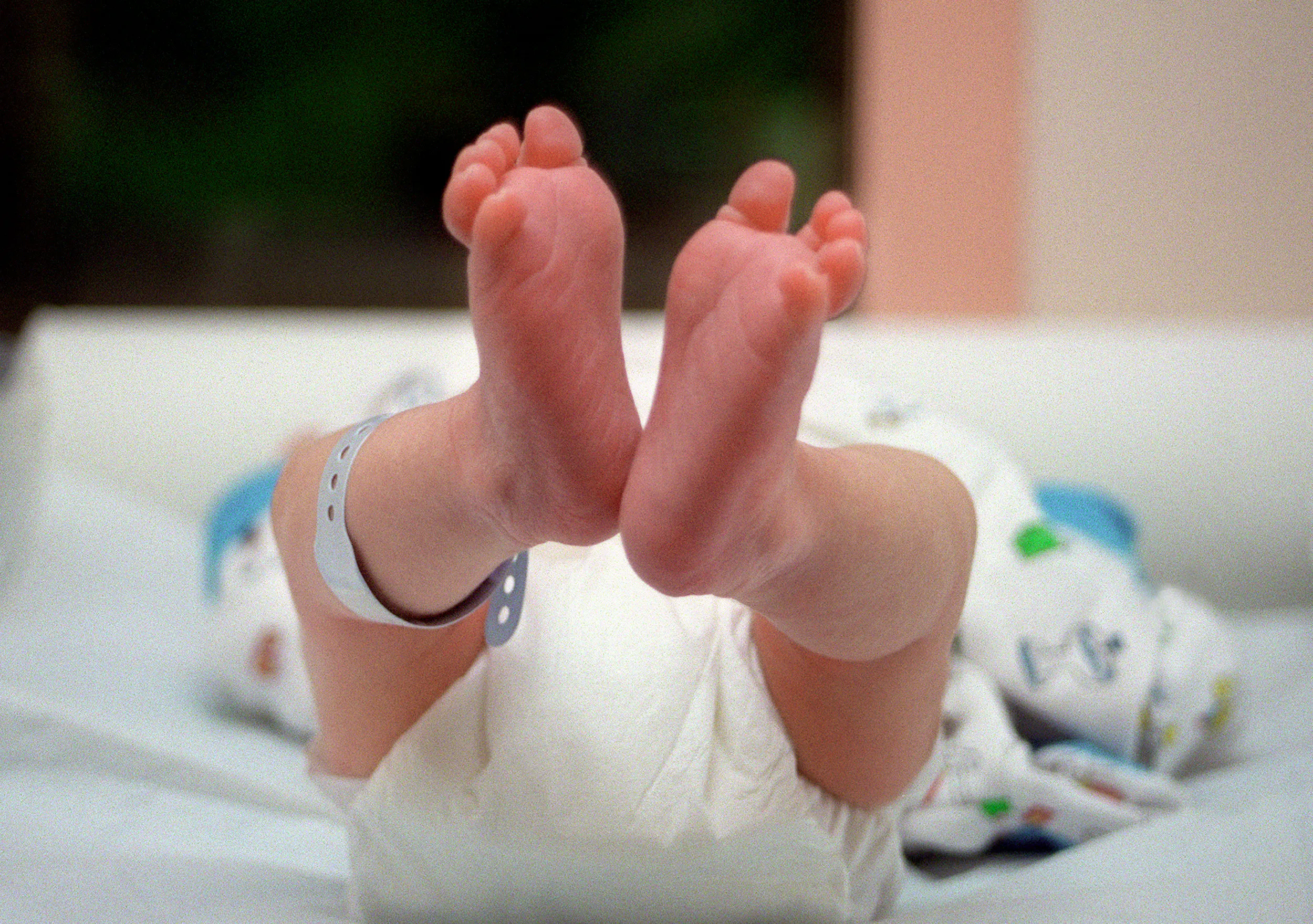 A pair of baby's feet, dangling in the air.
