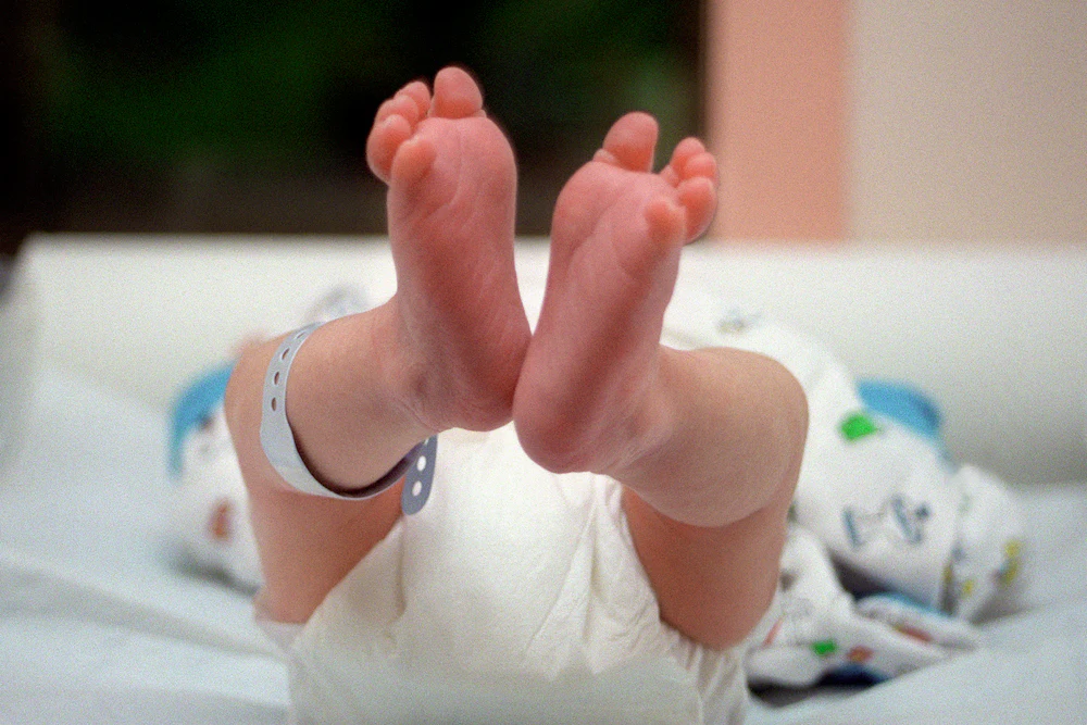 A pair of baby's feet, dangling in the air.