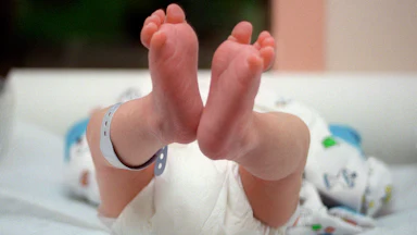 A pair of baby's feet, dangling in the air.