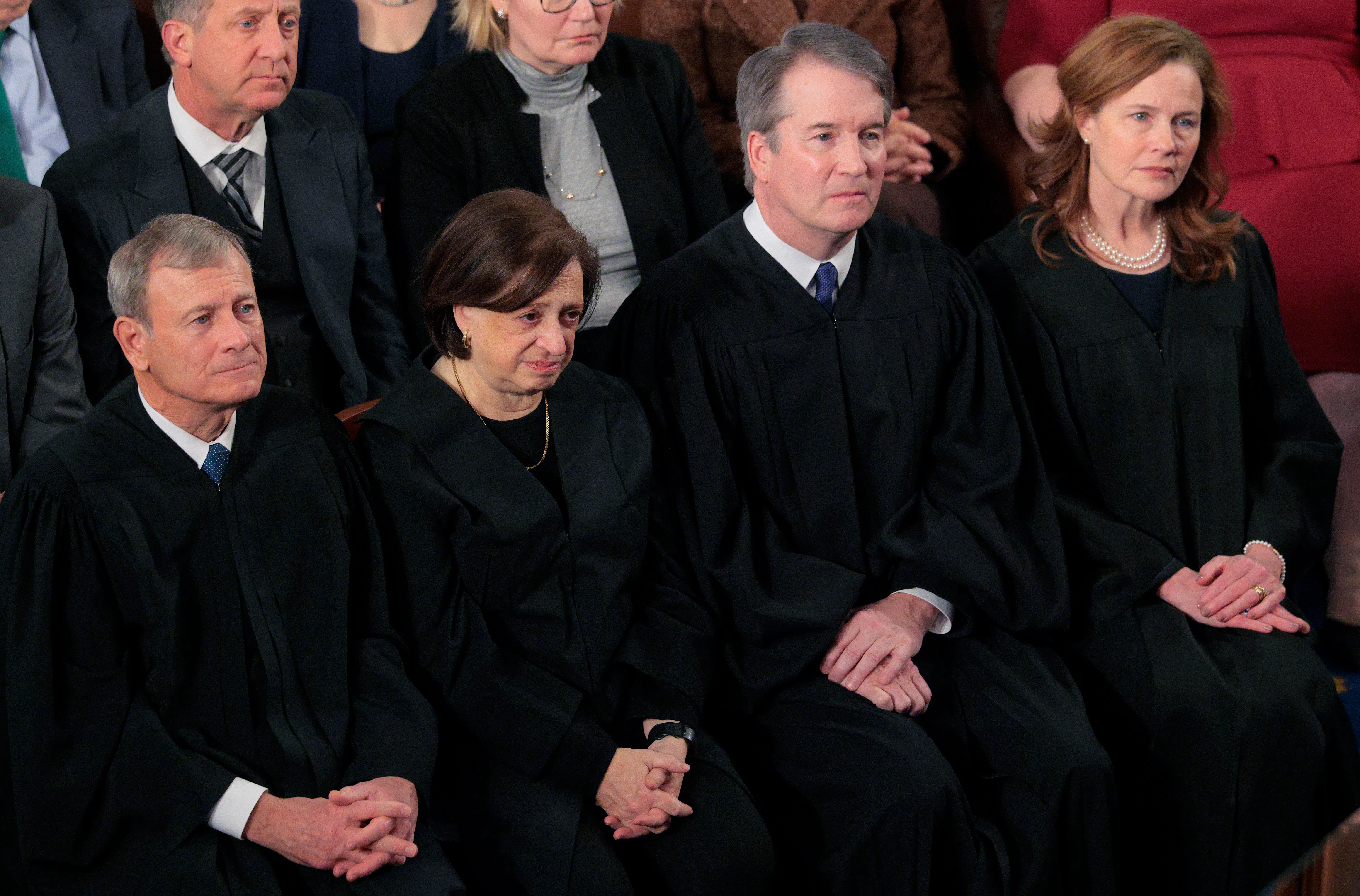 Supreme Court Chief Justice John Roberts, Associate Justice Elena Kagan, Associate Justice Brett Kavanaugh, and Associate Justice Amy Coney Barrett sit side by side.