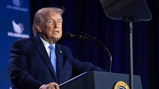 Donald Trump grimaces while standing at a podium