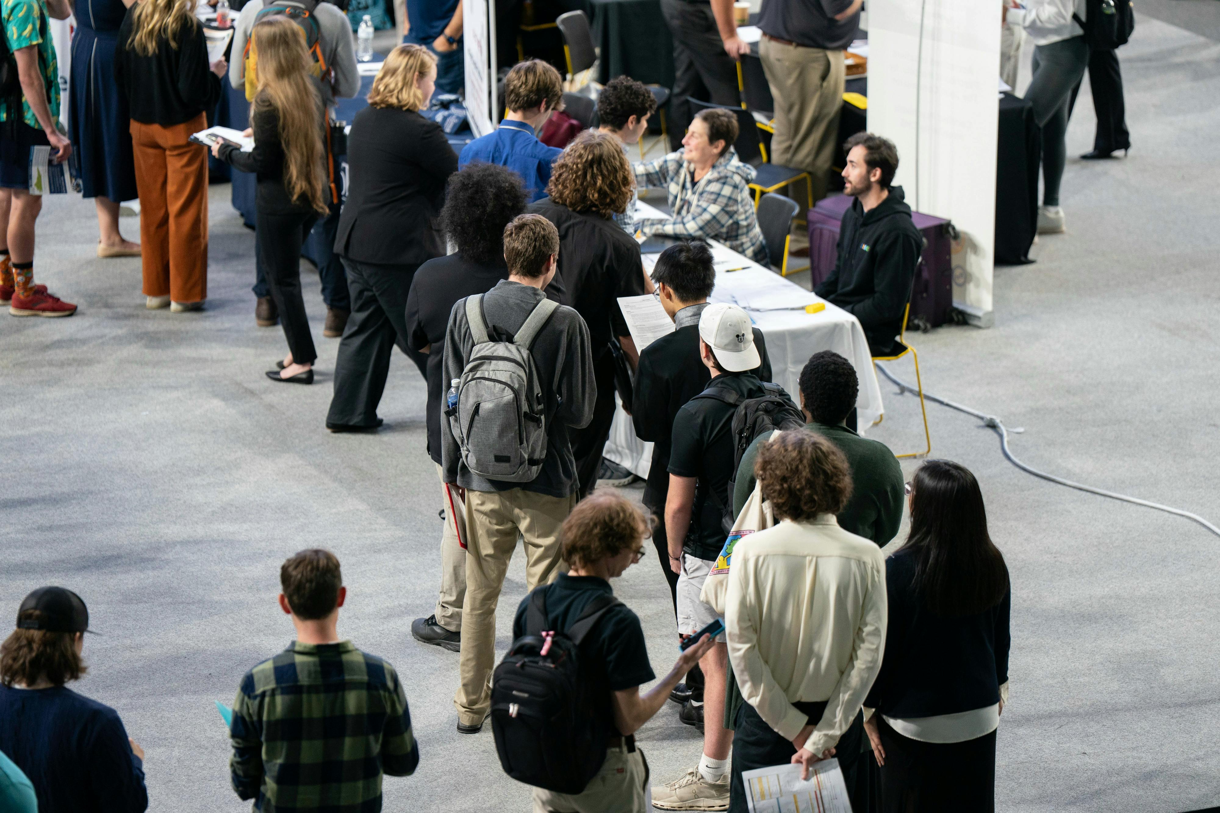 People stand in a line at a job fair.