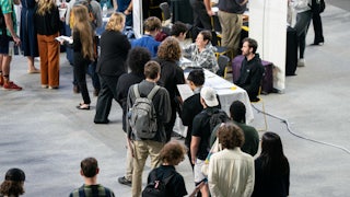 People stand in a line at a job fair.