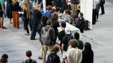 People stand in a line at a job fair.