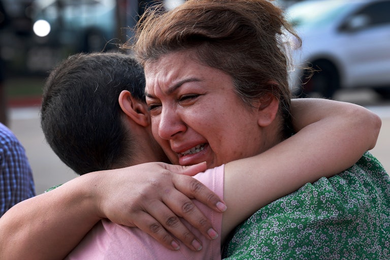 Nisreen Hajaj is comforted during a visit to a memorial near the scene of the May 9 mass shooting at an outlet mall in Allen, Texas