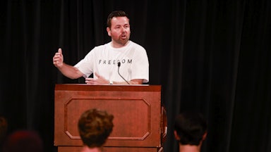 Indiana Lt. Governor Micah Beckwith speaks at a podium while wearing a Freedom t-shirt.
