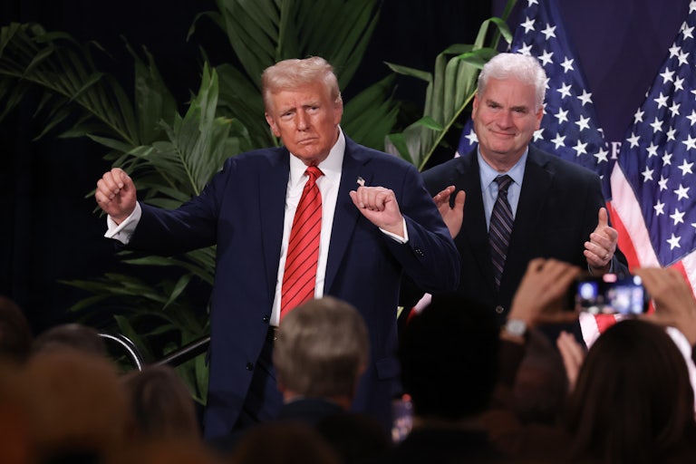 Donald Trump dances on stage while Tom Emmer stands behind him and claps