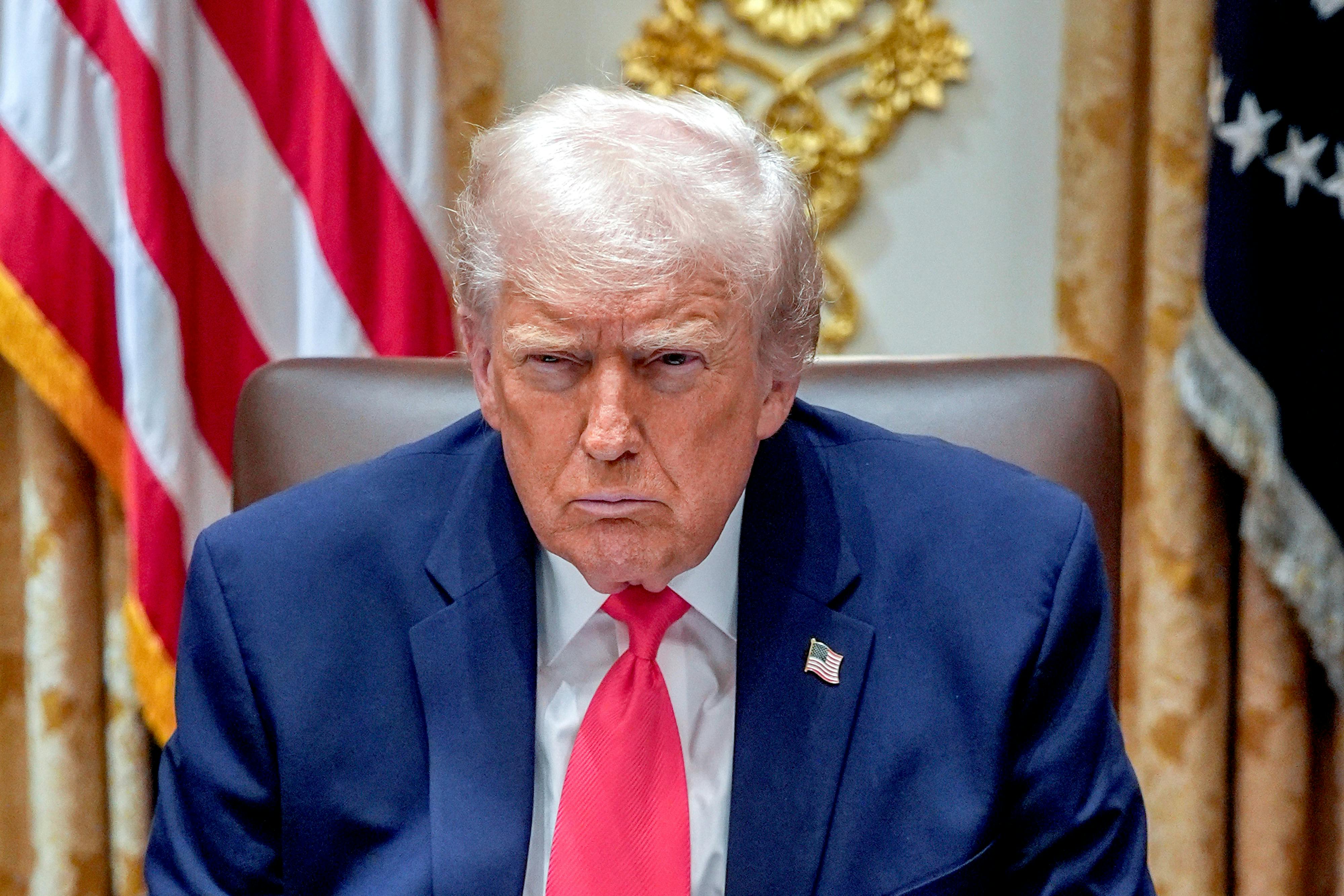 Donald Trump frowns while sitting in his Cabinet meeting