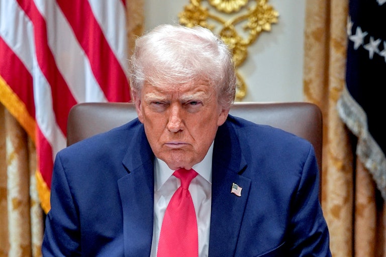 Donald Trump frowns while sitting in his Cabinet meeting