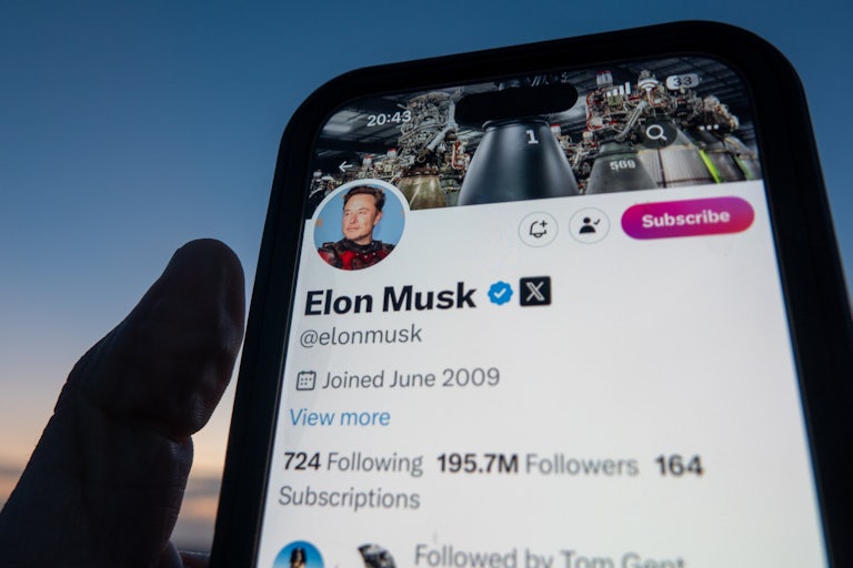A phone screen shows Elon Musk’s X (formerly Twitter) account