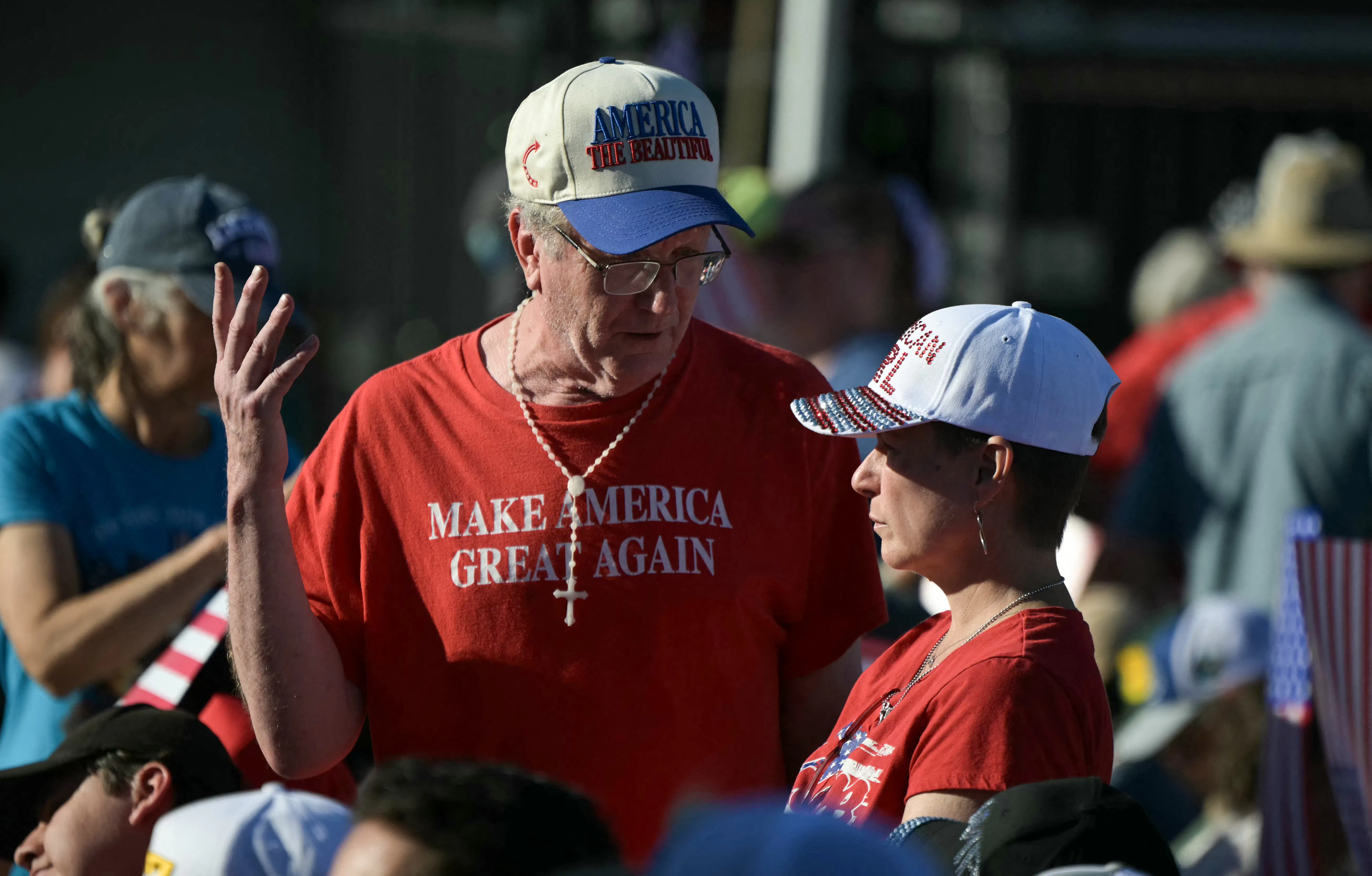 An attendee wears a “Make America Great Again” t-shirt while speaking to a younger woman whose shirt likely reads "Republicah Girl."