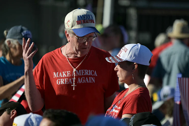 An attendee wears a “Make America Great Again” t-shirt while speaking to a younger woman whose shirt likely reads "Republicah Girl."