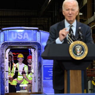 Biden speaks at a podium in front of a train.