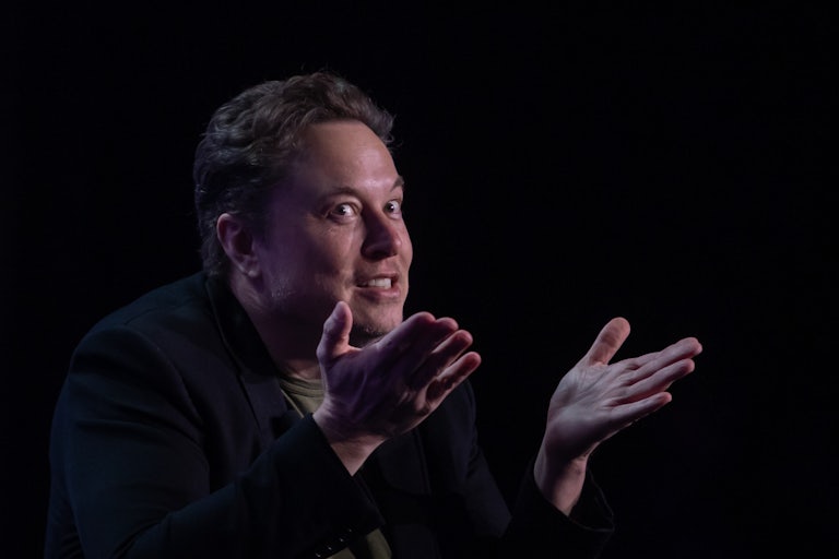 Elon Musk gestures while making a weird face