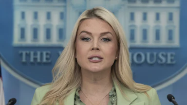 Karoline Leavitt stares from behind a podium