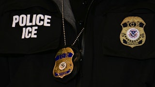 A close-up of an ICE agent's vest and badge