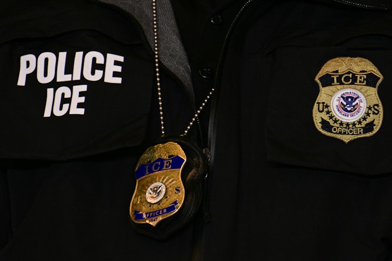 A close-up of an ICE agent's vest and badge