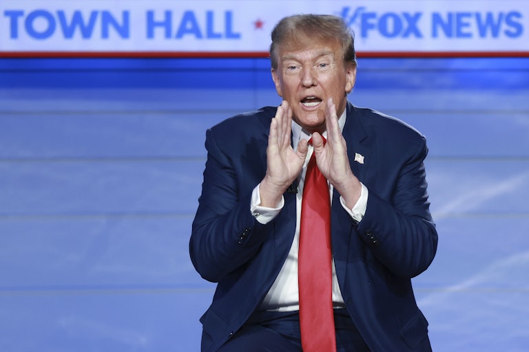 Donald Trump sits and yells, his hands cupping his mouth. Behind him reads "TOWN HALL * FOX NEWS."