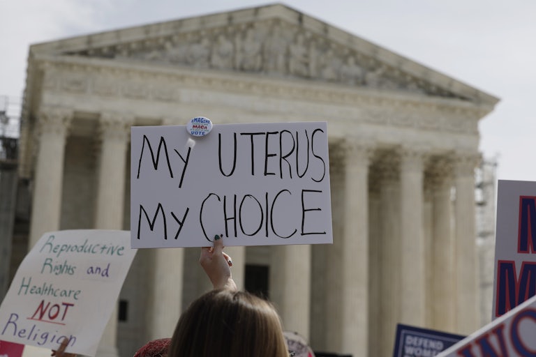 People hold up pro-abortion protest signs outside the Supreme Court