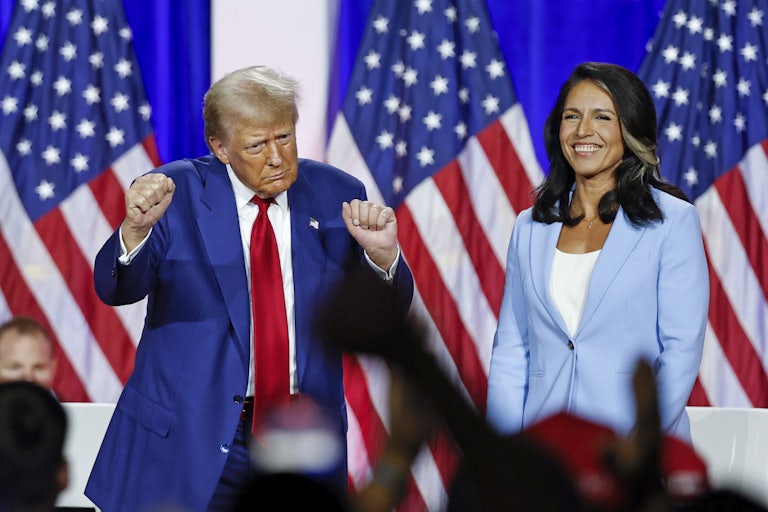 Donald Trump dances while standing next to Tulsi Gabbard, who smiles