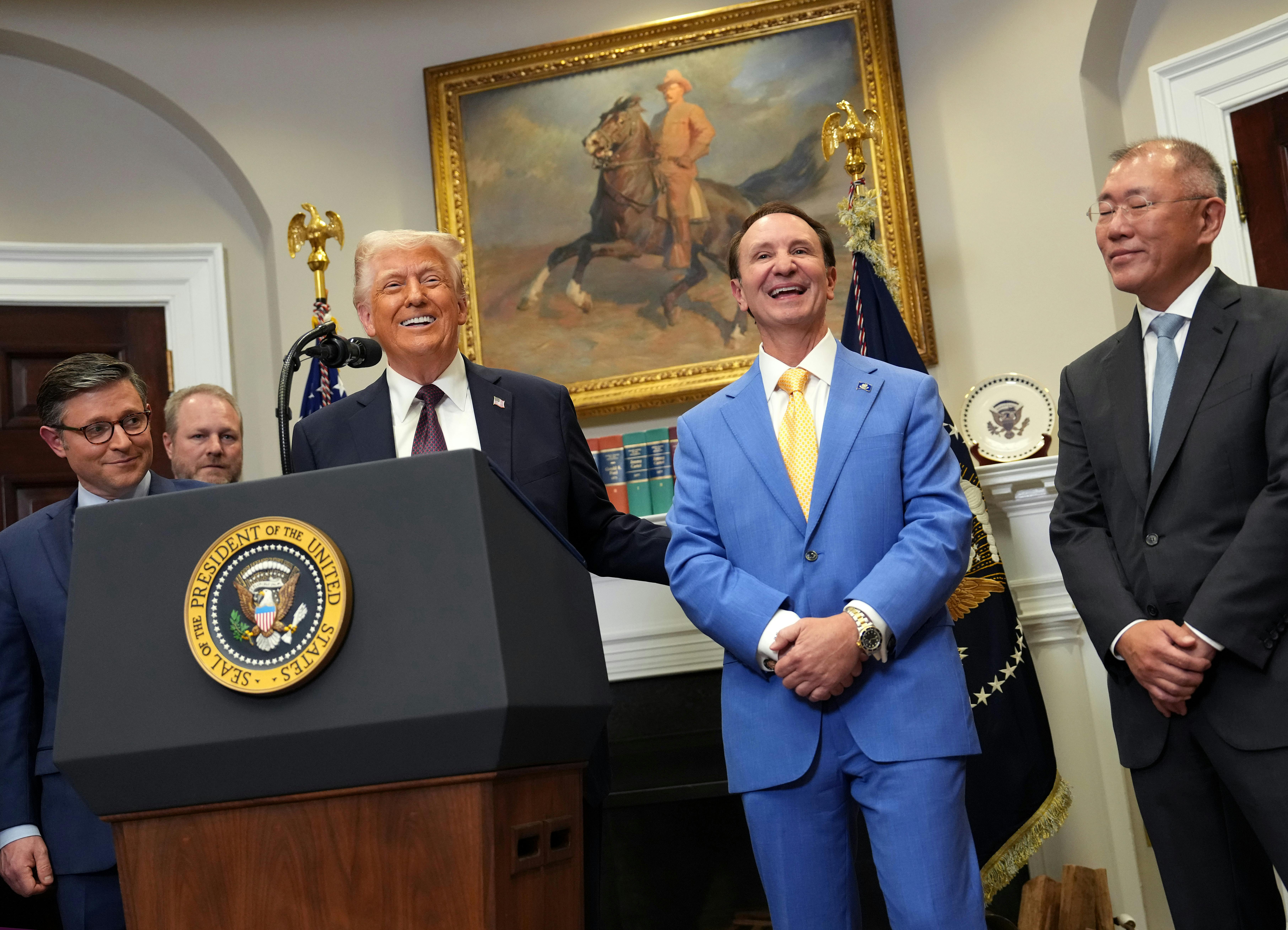 Donald Trump and Lousiana Governor Jeff Landry laugh in the Oval Office of the White House, along with others.