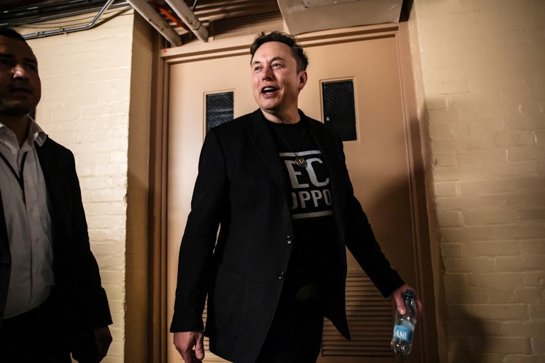 Elon Musk walks in the Capitol wearing a "Tech Support" T-shirt.