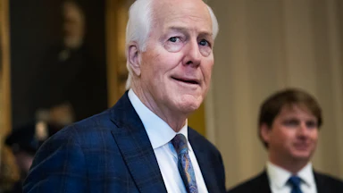 Senator John Cornyn looks to the side while walking in the Capitol