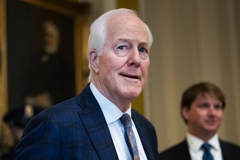 Senator John Cornyn looks to the side while walking in the Capitol