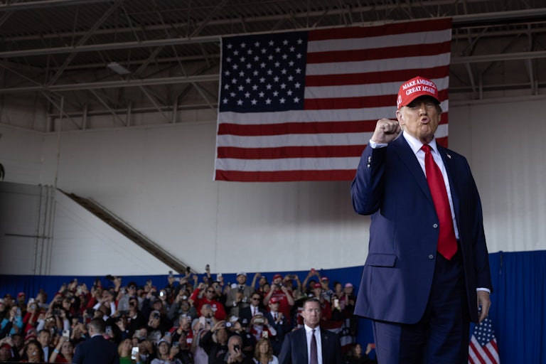 Donald Trump pumps his fist and purses his lips at a campaign event