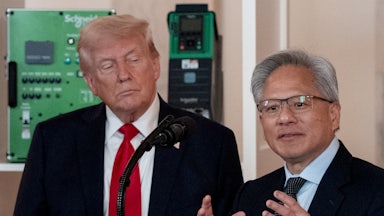 Donald Trump watches as Nvidia CEO Jensen Huang gestures and speaks at a podium