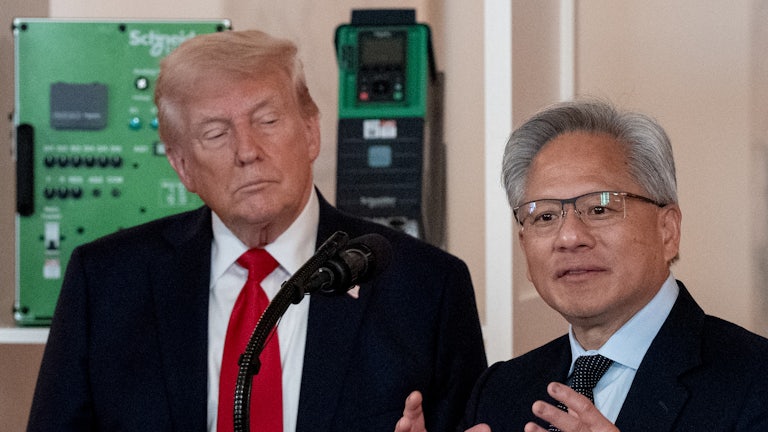 Donald Trump watches as Nvidia CEO Jensen Huang gestures and speaks at a podium