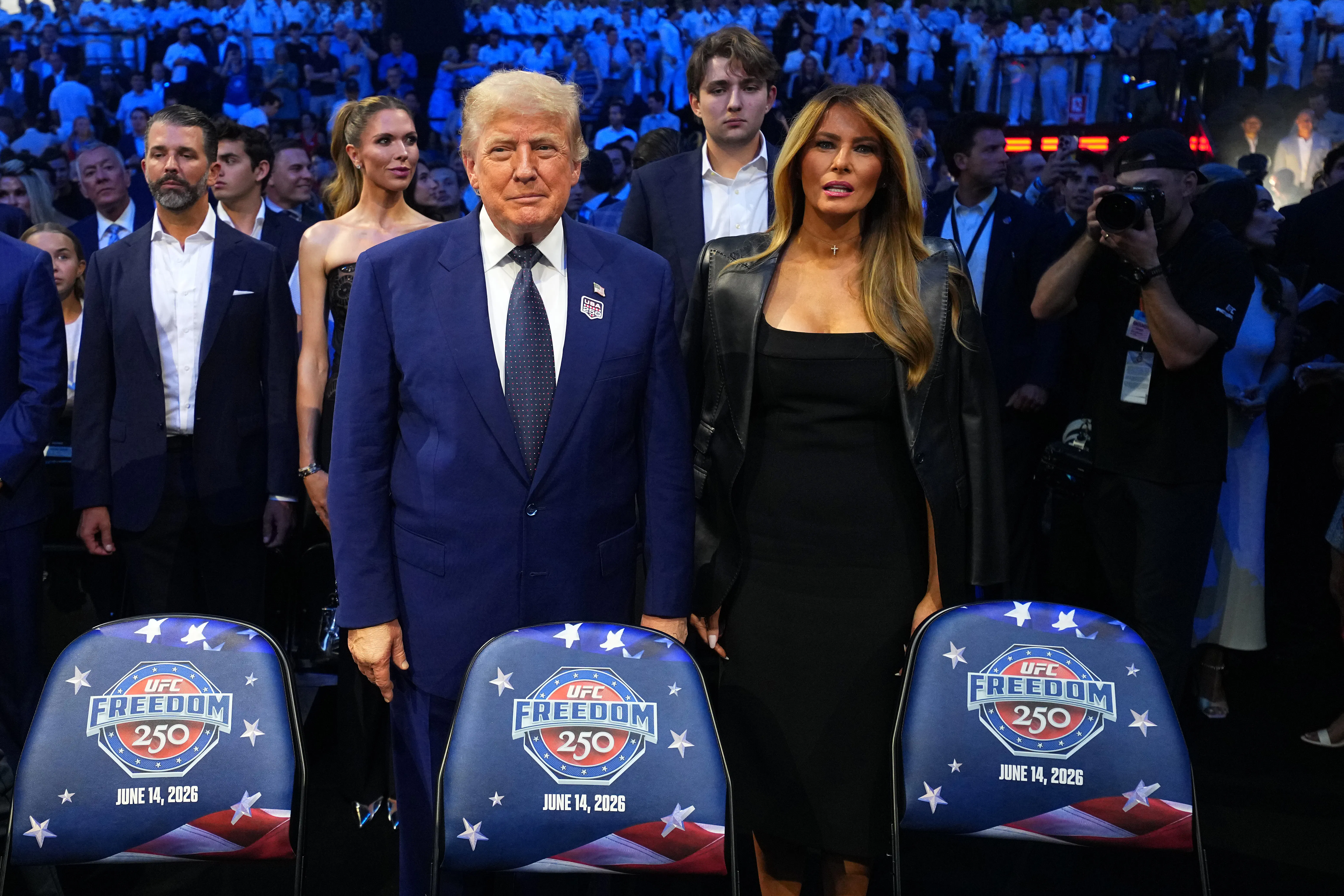 Donald Trump stands next to Melania Trump. They do not hold hands.