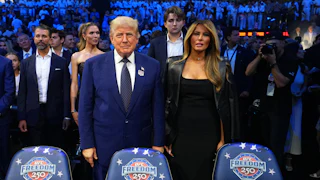 Donald Trump stands next to Melania Trump. They do not hold hands.