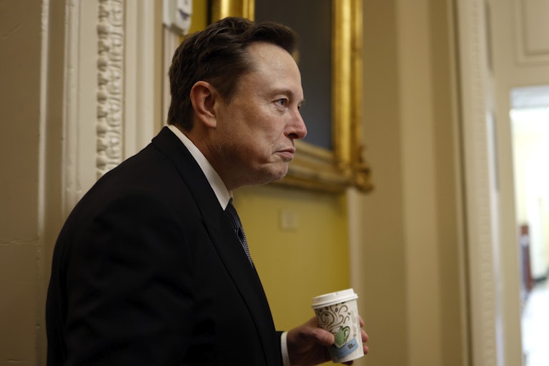 Elon Musk holds a to-go cup while visiting the Capitol