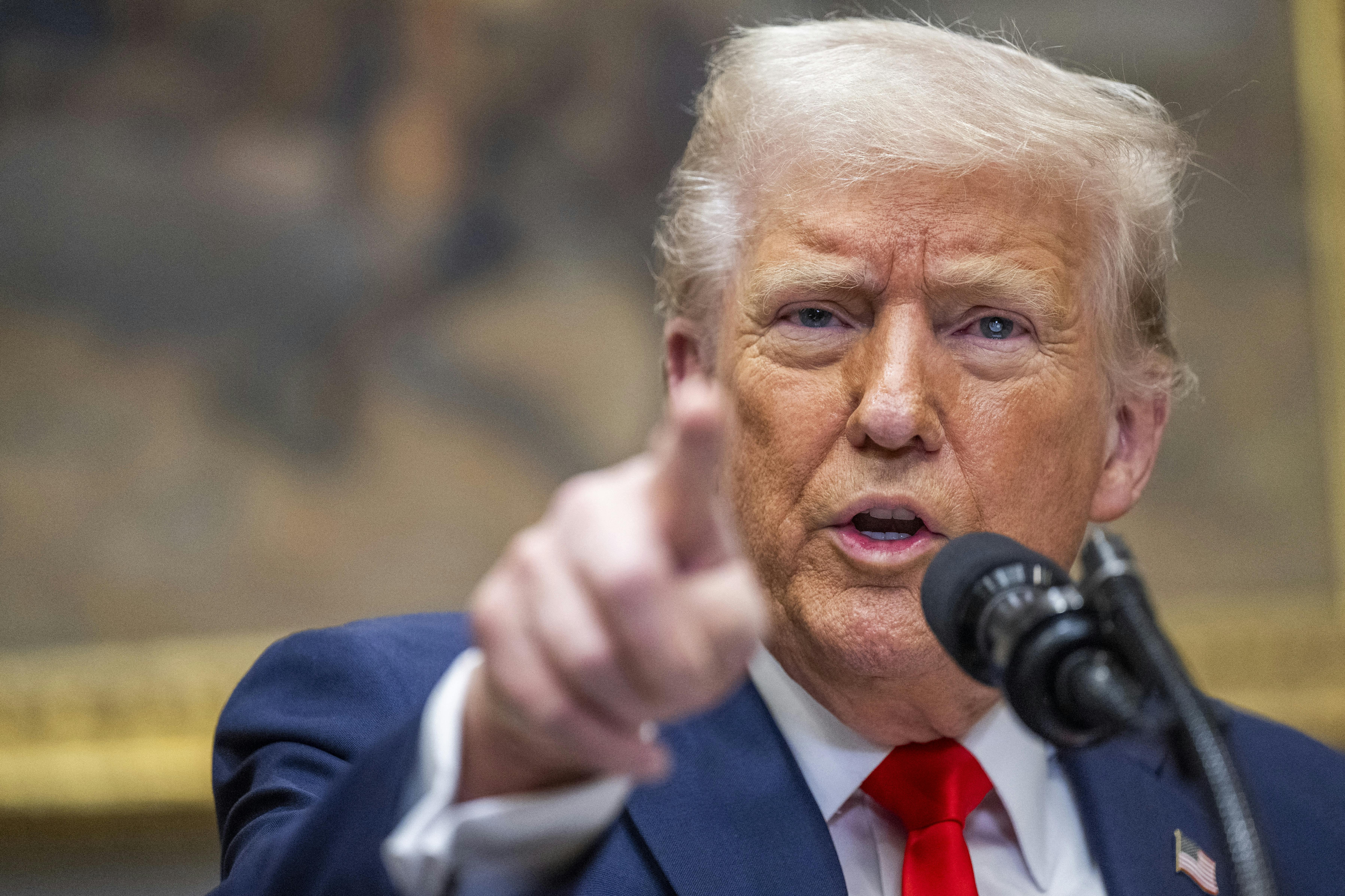 Donald Trump points as he speaks at a press conference.