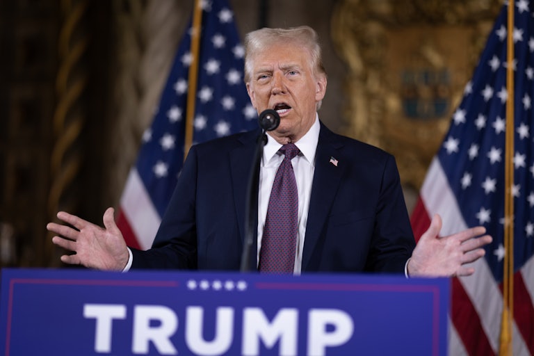 Donald Trump gestures while speaking at a podium