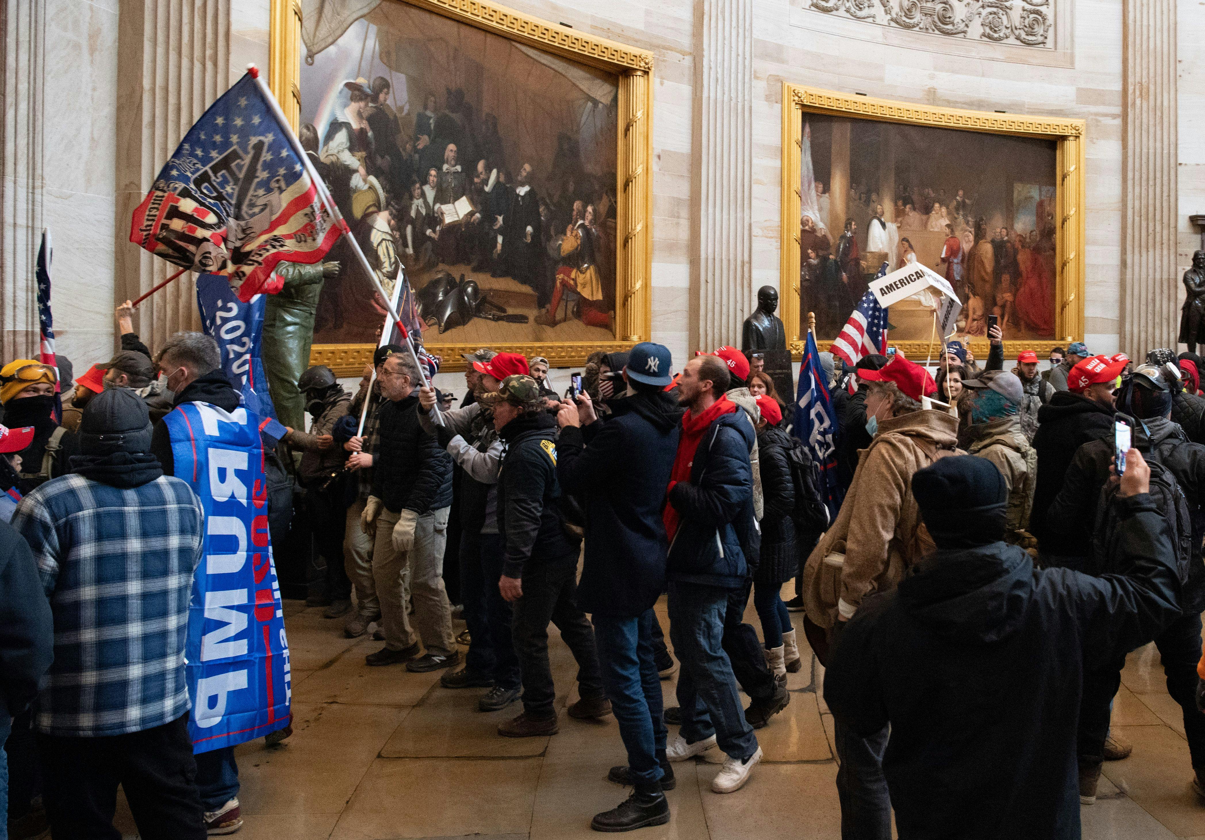 A mob of Trump supporters standing in the Capitol rotunda with Trump flags on January 6, 2021. 