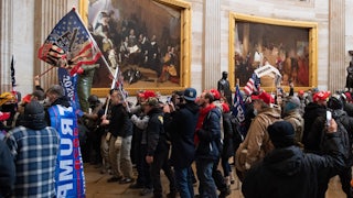 A mob of Trump supporters standing in the Capitol rotunda with Trump flags on January 6, 2021.