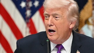 Donald Trump turns his head to the side while speaking into a microphone