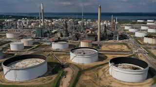 This photo shows smokestacks and industrial buildings near a body of water.