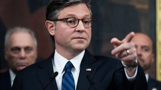 House Speaker Mike Johnson points while standing at a podium during a press conference