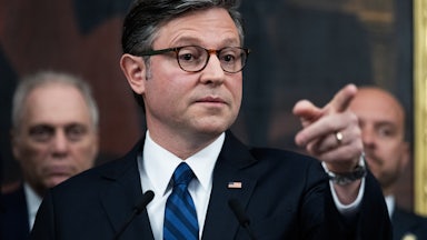 House Speaker Mike Johnson points while standing at a podium during a press conference