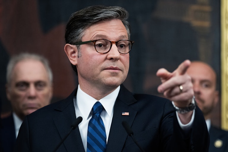 House Speaker Mike Johnson points while standing at a podium during a press conference