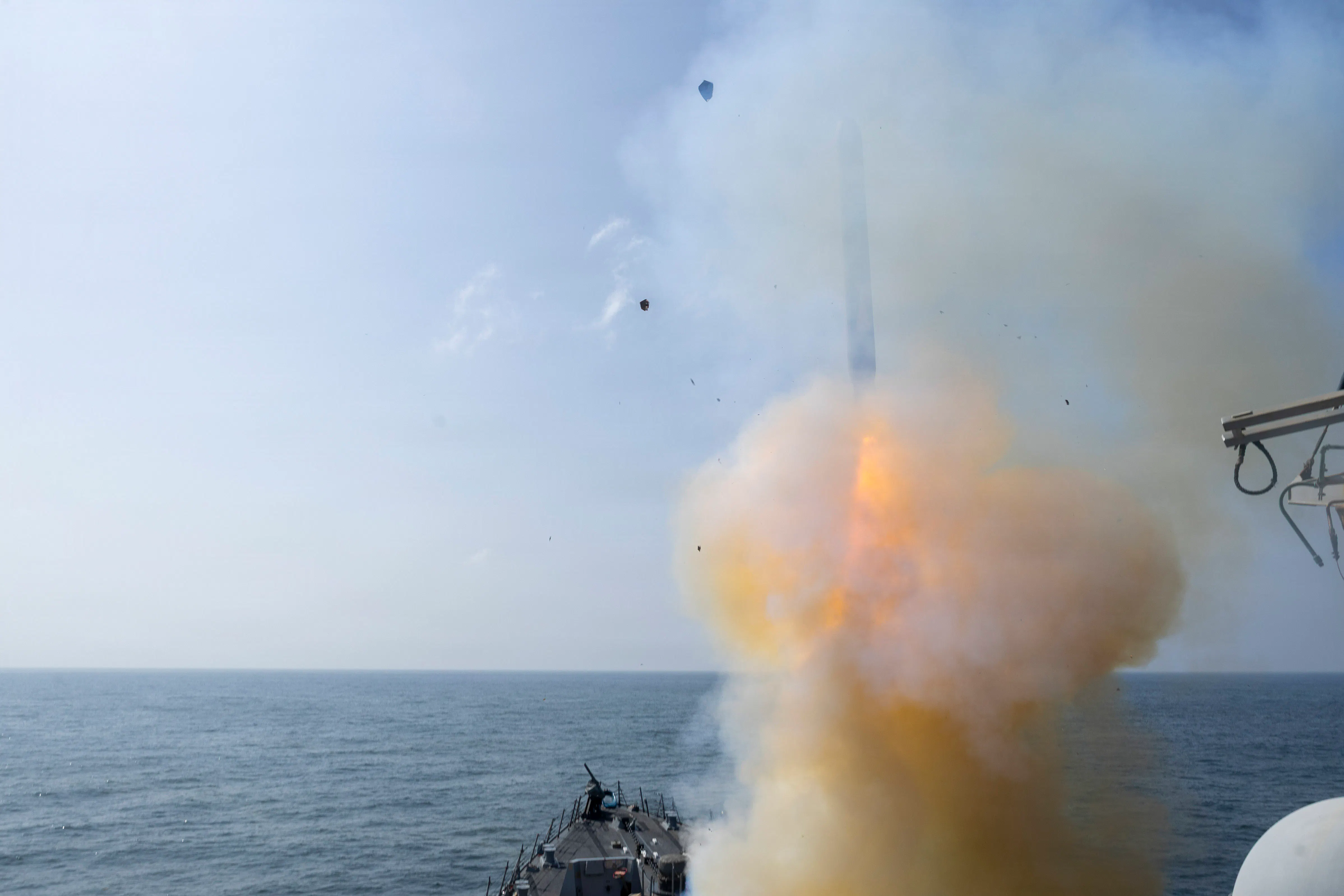 A Tomahawk land attack missile is launched in the sea amid a cloud of smoke.