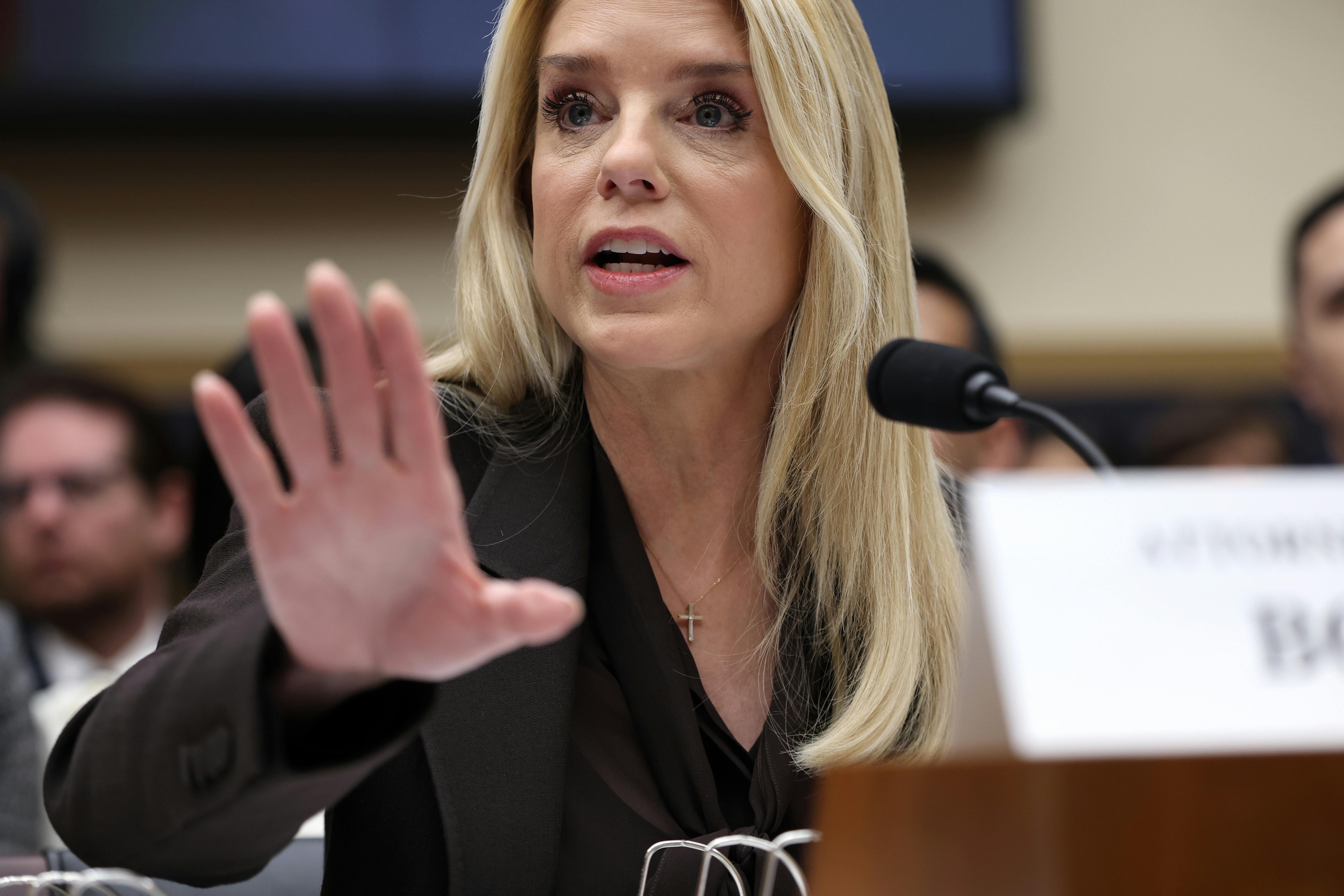 Attorney General holds out her hand while speaking during a House committee hearing