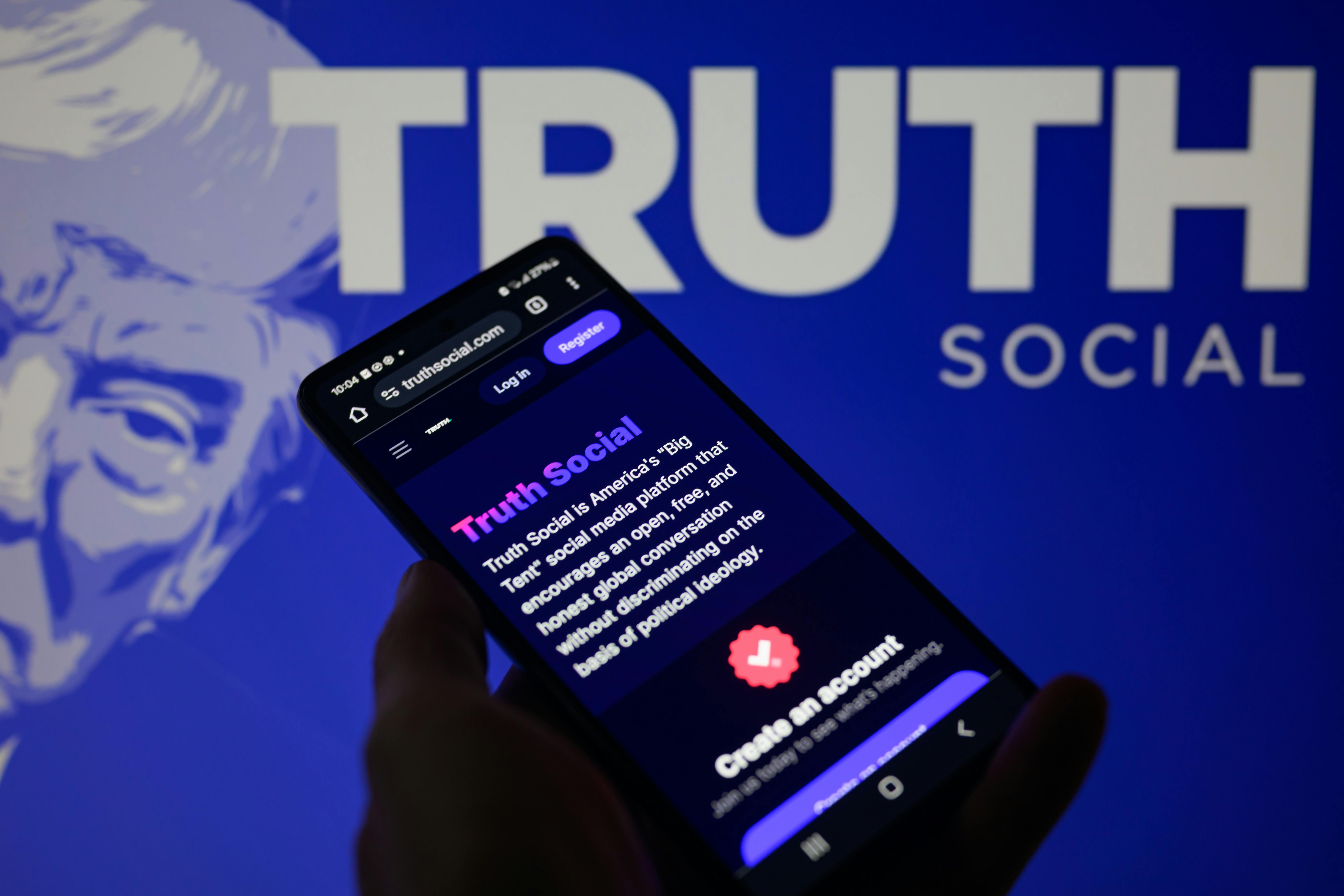 The Truth Social app is being displayed on a smartphone with Truth Social visible in the background in this photo illustration.