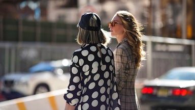 Two women stand on a street in New York City