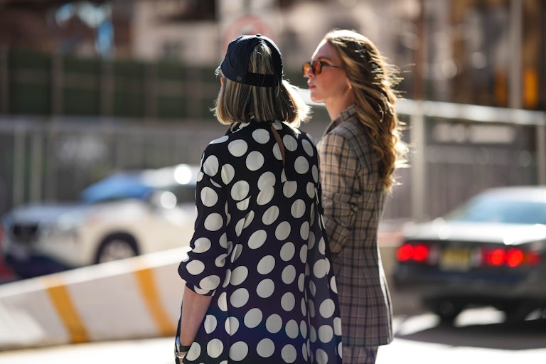Two women stand on a street in New York City