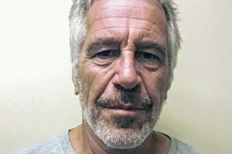A mugshot of a bearded Jeffrey Epstein with an off-white background.